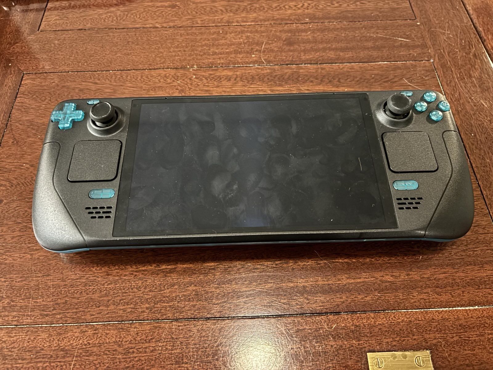 The front of the steam deck, sporting green buttons and triggers in lieu of the old black ones